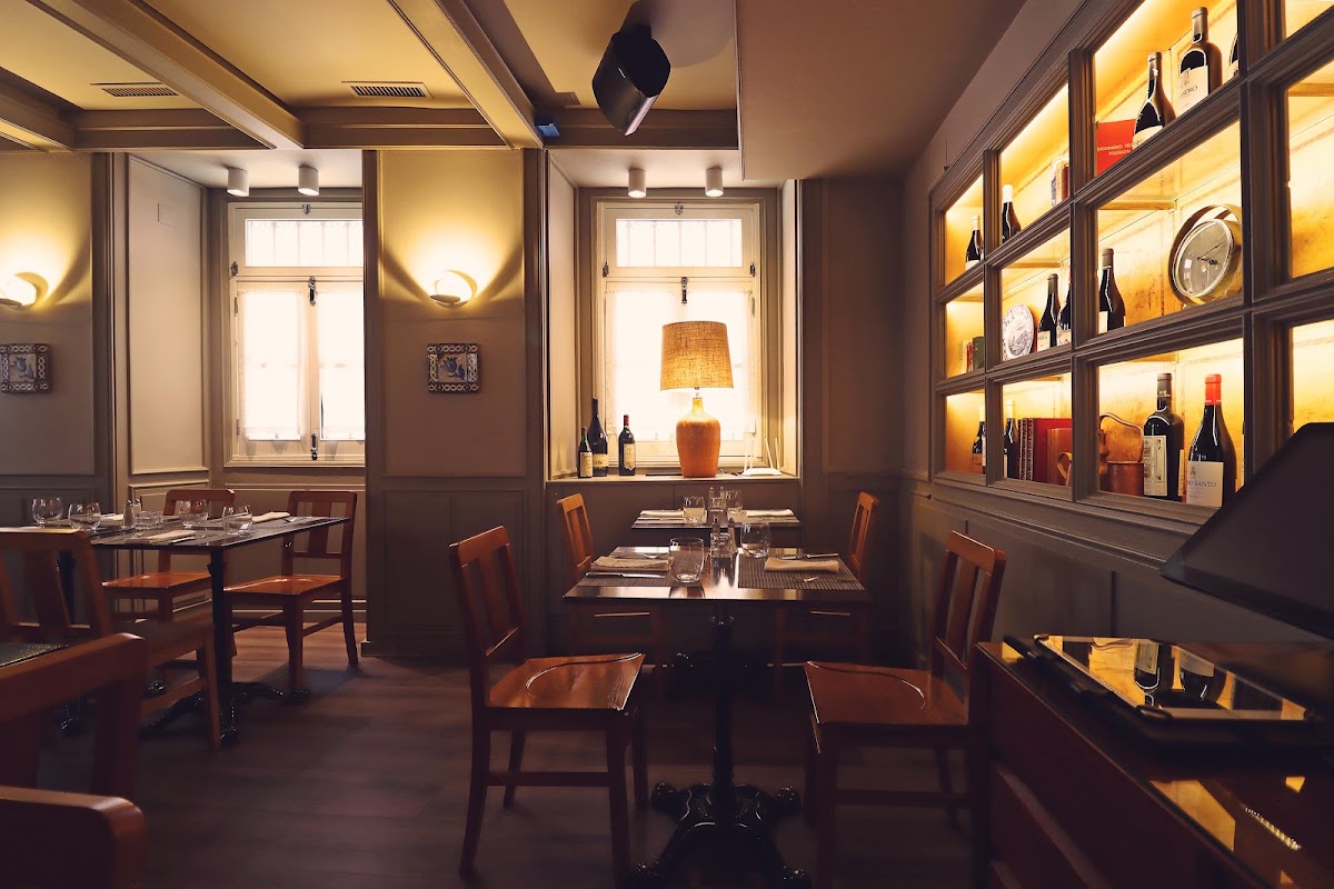 Warmly lit restaurant interior with a backlit wine shelving unit